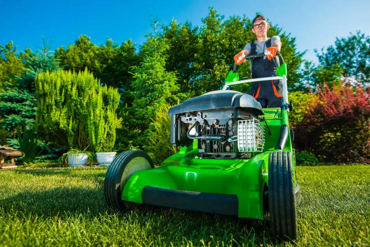 Gardener Mowing Backyard Lawn