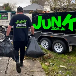 A Man Carrying a Black Trash Bag