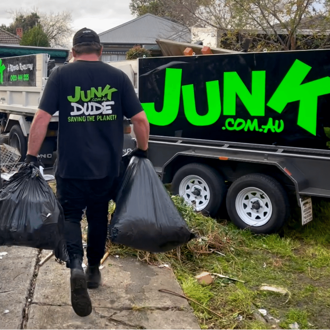 A Man Carrying a Black Trash Bag